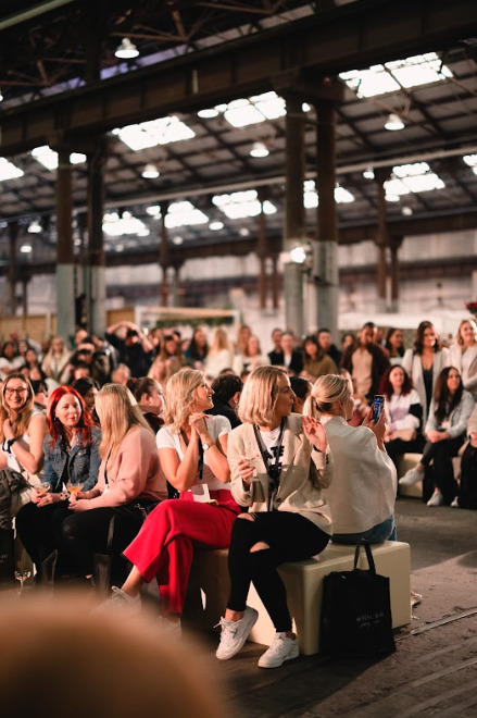 Candid photo of the crowd reacting to the runway show.