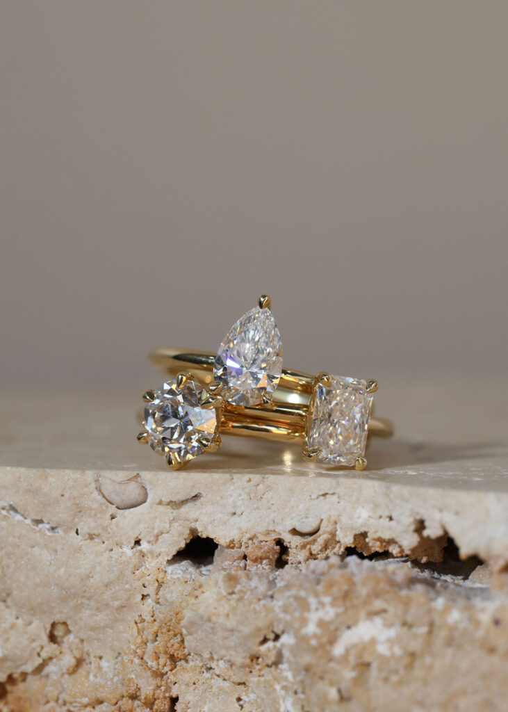 Gold diamond ring showcased on marble slab, highlighting elegant craftsmanship of the best engagement rings Sydney