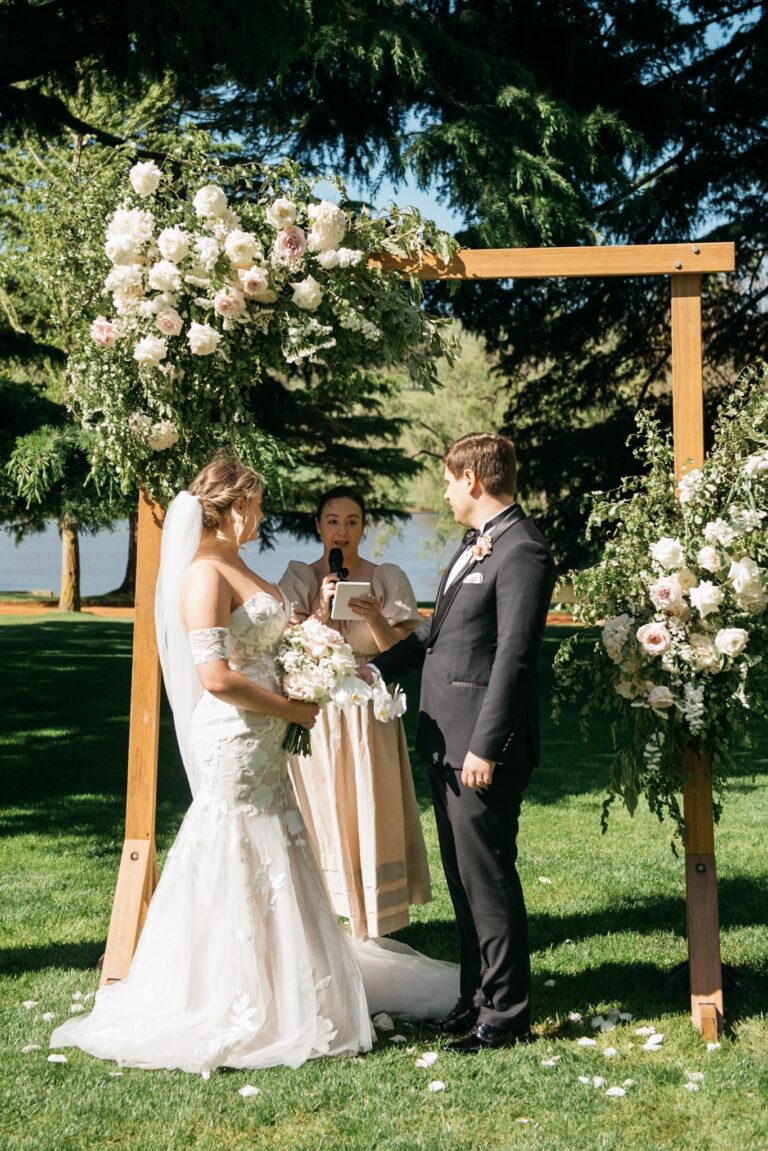 A beautiful outdoor wedding ceremony in the park surrounded by lush green trees and colorful flowers.
