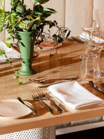 Wedding reception table with green vase and elegant place settings, styled by Dann Event Hire, best wedding event hire Melbourne.