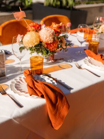 Elegant wedding table setting with orange napkins and place settings by Social Event Hire, best wedding event hire Melbourne.