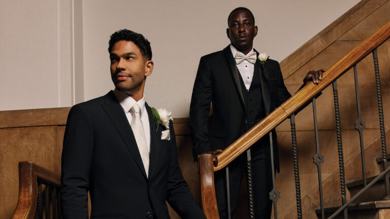 Two gentlemen wearing Politix men's wedding suits in a modern, elegant setting