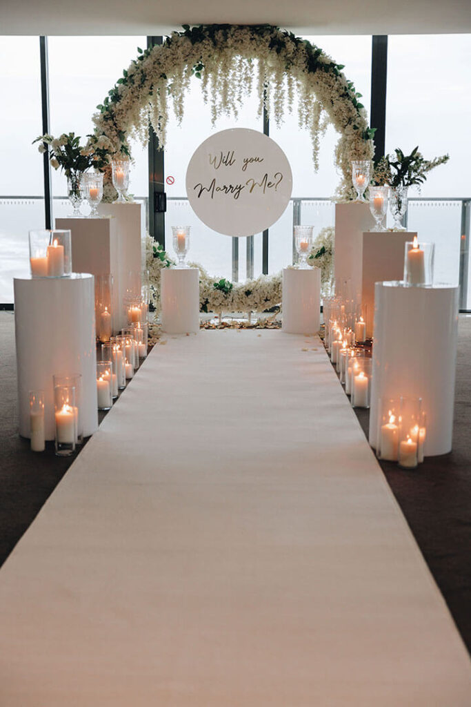 Wedding aisle setup with floral decorations and white chairs by You're Invited Event Hire, best wedding event hire Melbourne.