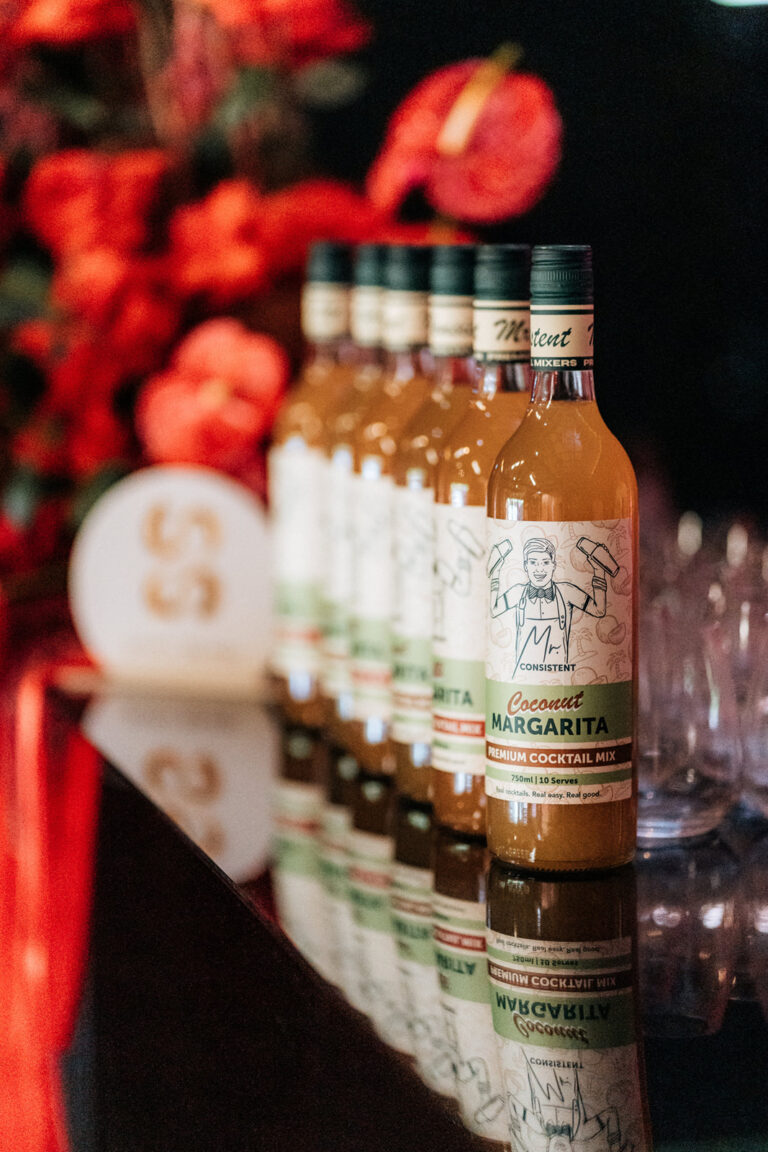 A table with various liquor bottles lined up in a row.