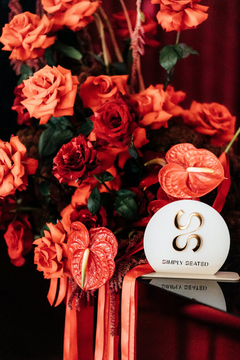 A bouquet of red roses with a white sign.