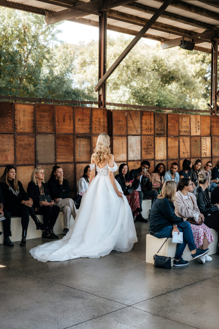 A bride walking down the aisle at her wedding, surrounded by flowers and loved ones.