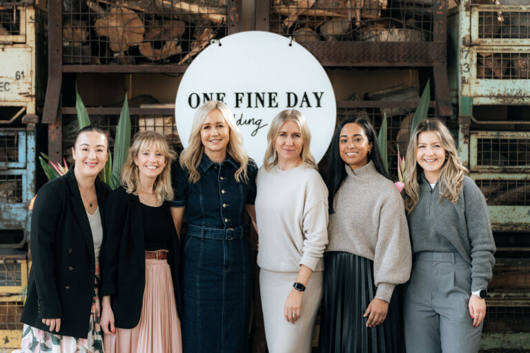 A group of people standing together, smiling and looking happy