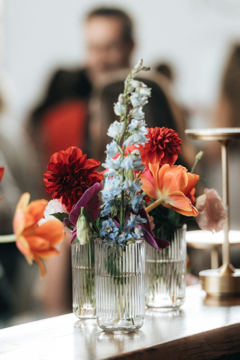 Colorful flowers in vases on a restaurant table.