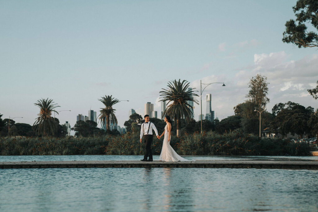 Newlyweds walking hand in hand at Lakeside Pavilion, one of the best wedding venues in Melbourne.