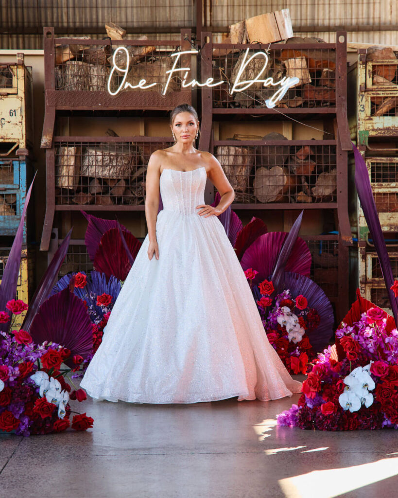 Model posing in a strapless lace ball gown wedding dress at a bridal runway show in Melbourne.