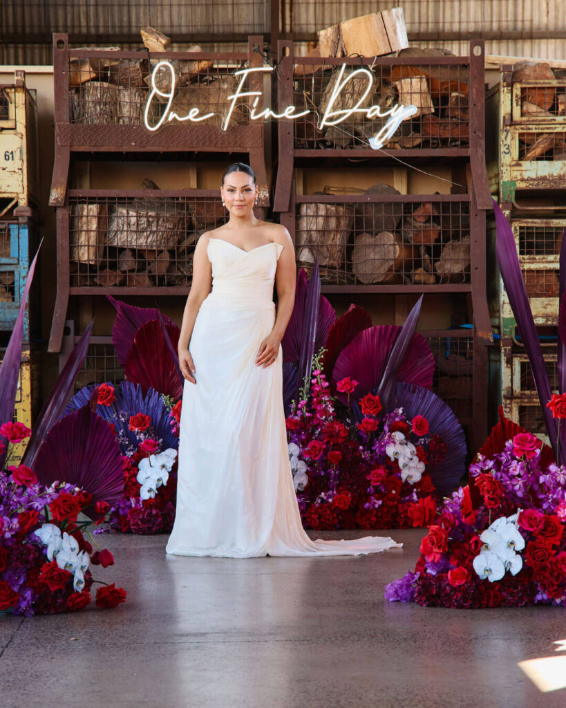 Model posing in a strapless floor-length wedding dress at a bridal runway show in Melbourne.