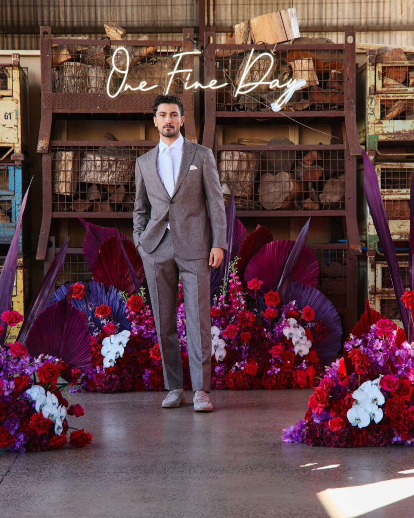 Man wearing a light grey wedding suit with white shirt and tie at a bridal runway show in Melbourne.