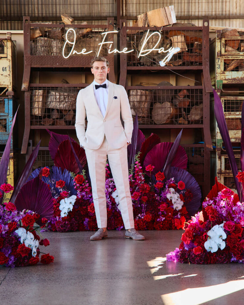 Man wearing a cream wedding suit with matching pants, black bow tie and white shirt at a bridal runway show in Melbourne.