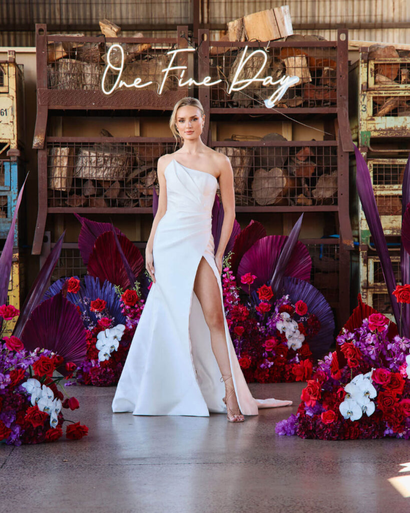 Elegant strapless fitted wedding dress with thigh-high slit showcased during a bridal runway show in Melbourne.