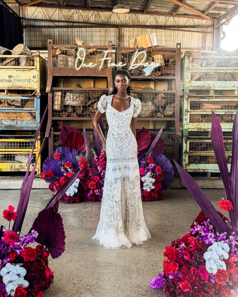 Woman posing in a stylish patterned puff sleeve wedding dress at a bridal runway show in Melbourne.