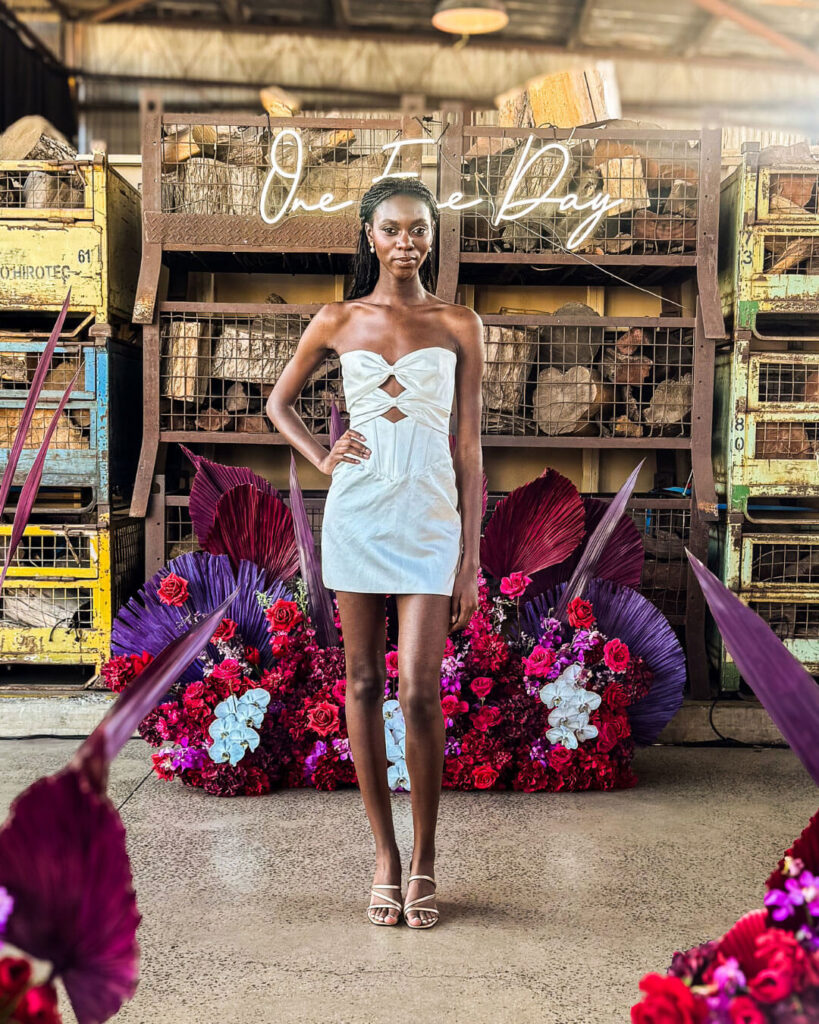 Model posing in a strapless under-the-knee fitted wedding dress with double chest cut-out at a bridal runway show in Melbourne.