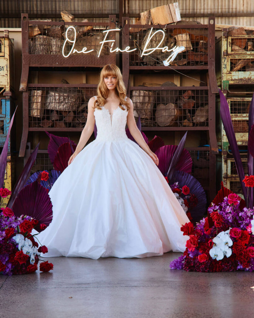 Strappy deep V-neck ball gown wedding gown with voluminous skirt showcased during a bridal runway show in Melbourne.