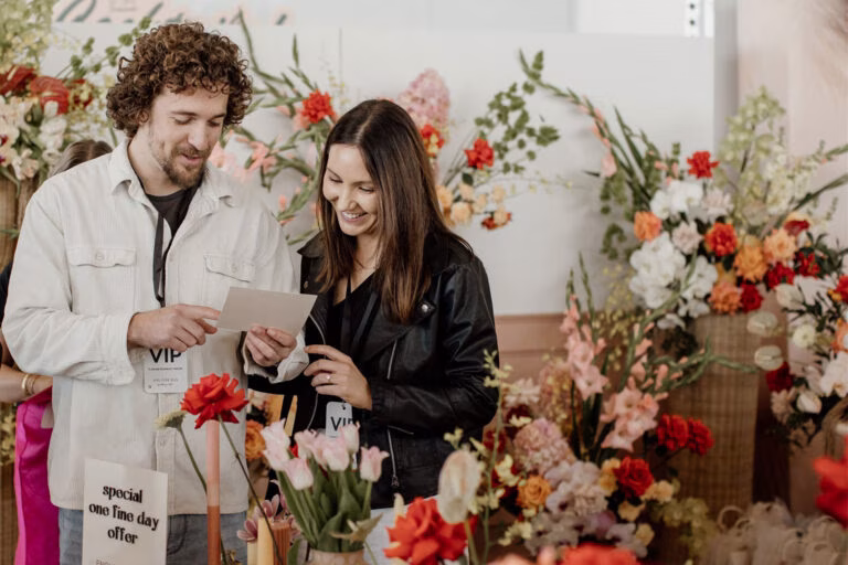 Couple exploring florist and other wedding vendors at the Wedding Expo