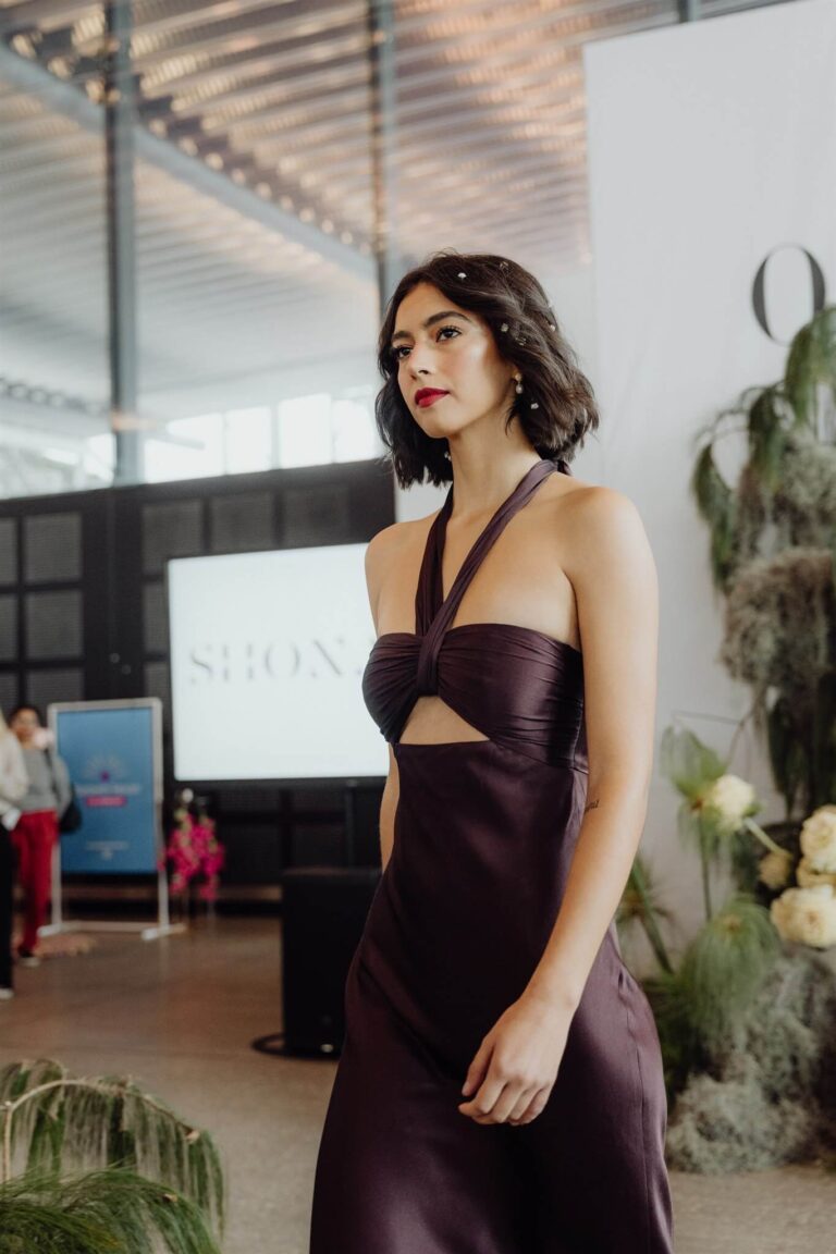 Close-up of satin bodice detail on dark maroon dress during runway walk at the wedding expo in Sydney 2025