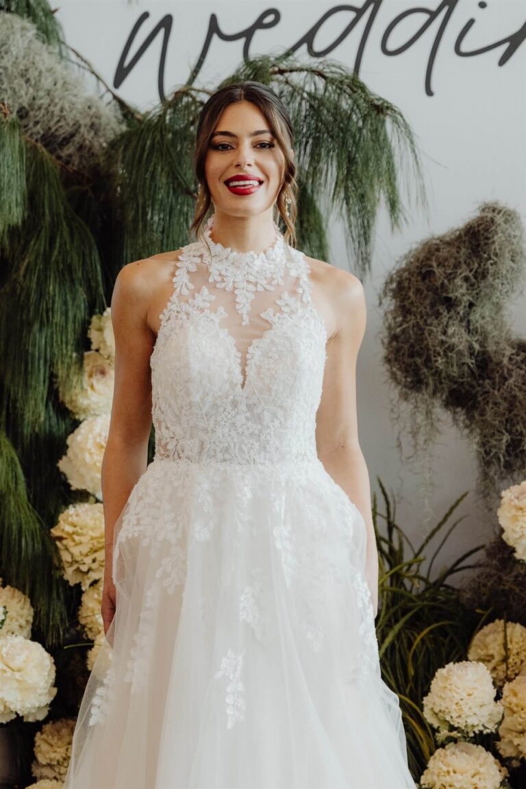 Elegant lace gown with high neckline and leaf detailing worn by model at the wedding expo in Sydney 2025