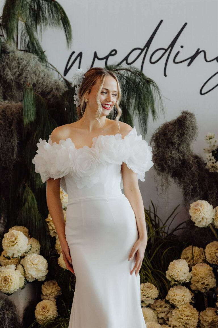 Elegant off-shoulder silk dress with detailed floral design on bodice showcased at wedding expo in Sydney 2025