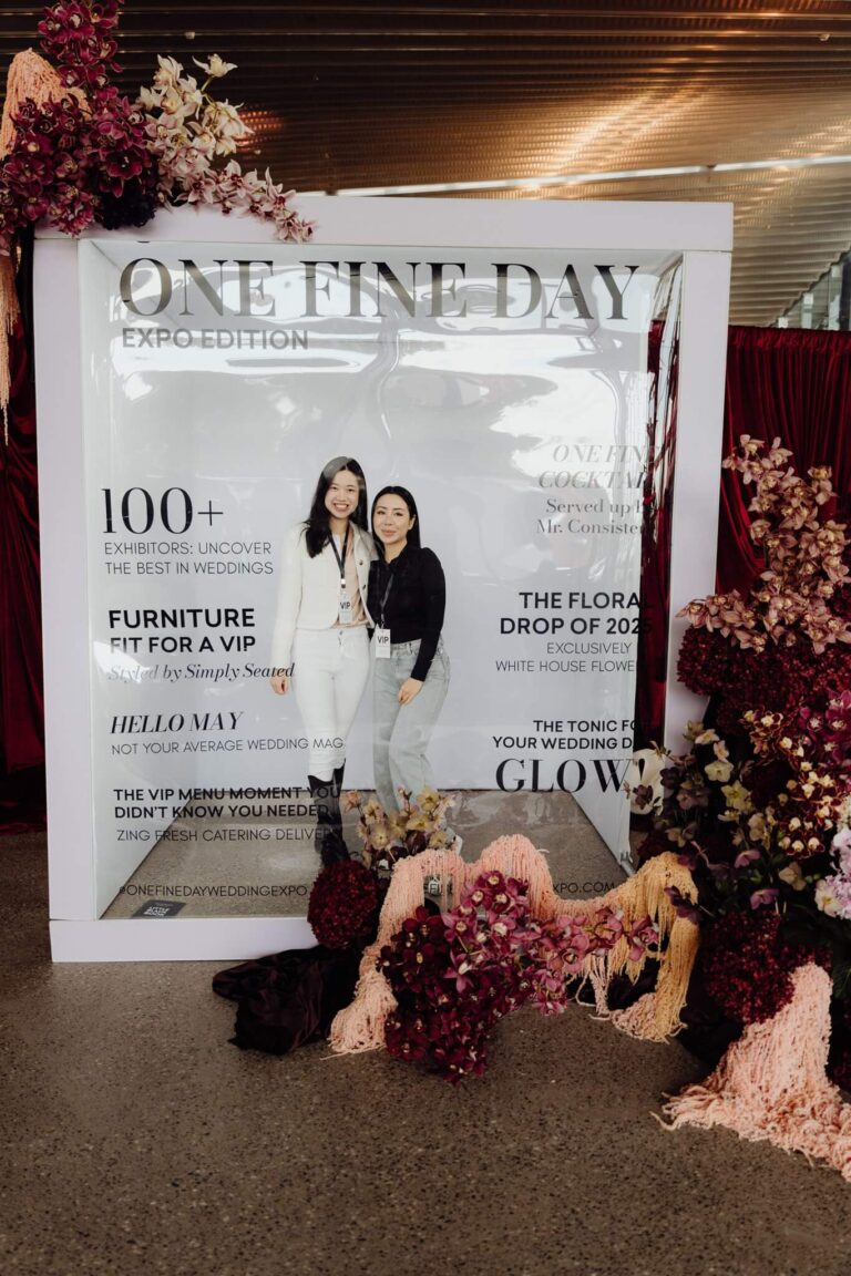 Wedding expo visitors smiling in front of One Fine Day photo backdrop at wedding expo in Sydney 2025