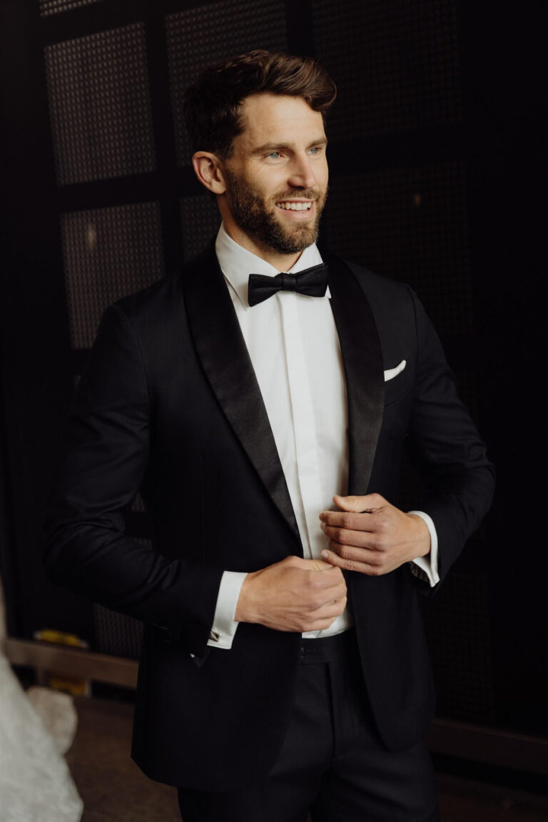 Close-up of model wearing black suit, pants, and bow tie at wedding expo in Sydney 2025