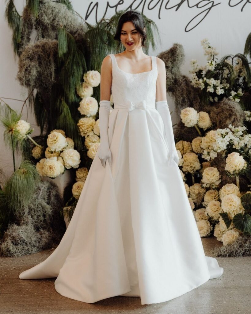 Model wearing satin sleeveless dress with elbow-length gloves at bridal runway show in Sydney 2025