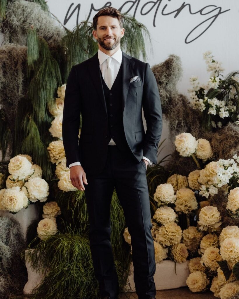 Model showcasing fitted black suit with vest and pants at bridal runway show in Sydney 2025