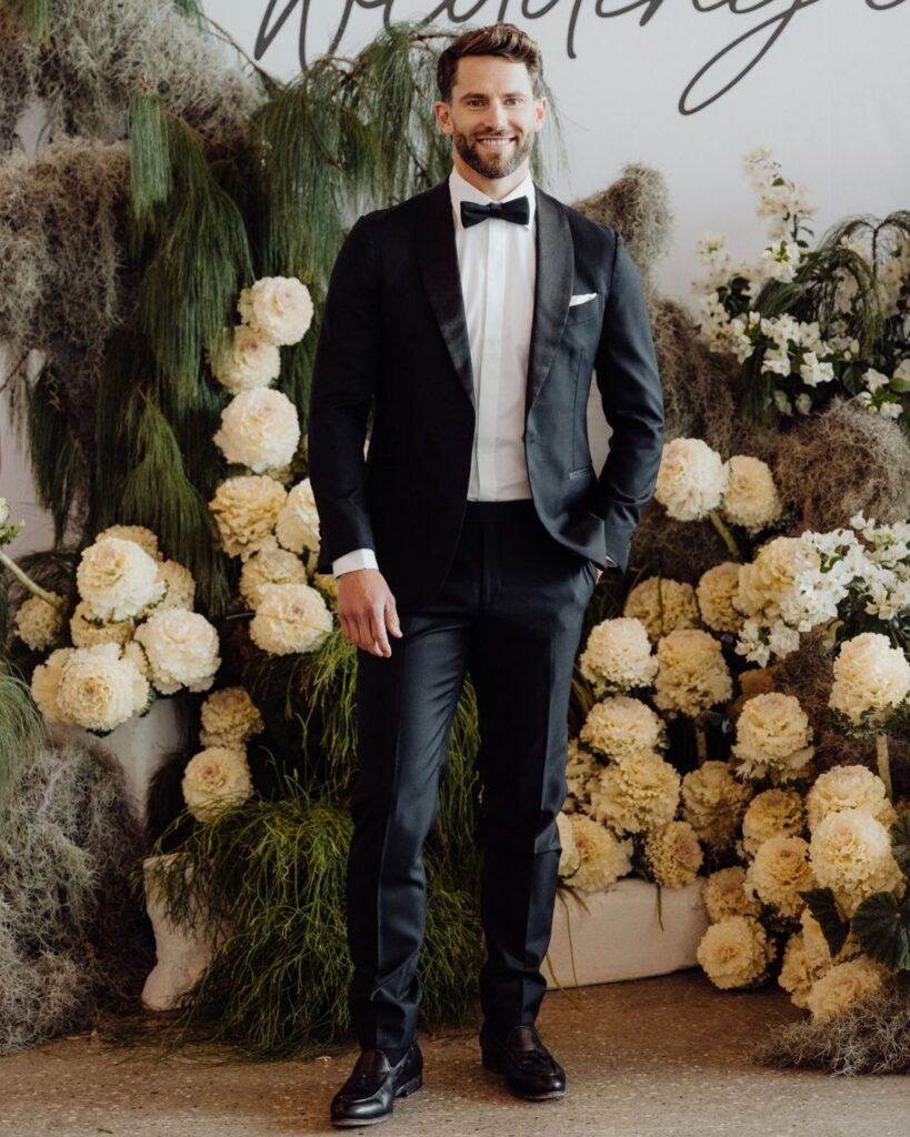 Close-up of male model in black satin suit and pants during bridal runway show in Sydney 2025
