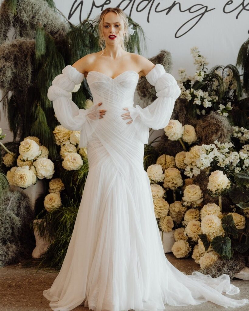 Model showcasing fitted tube-style long sleeve lace dress at bridal runway show in Sydney 2025