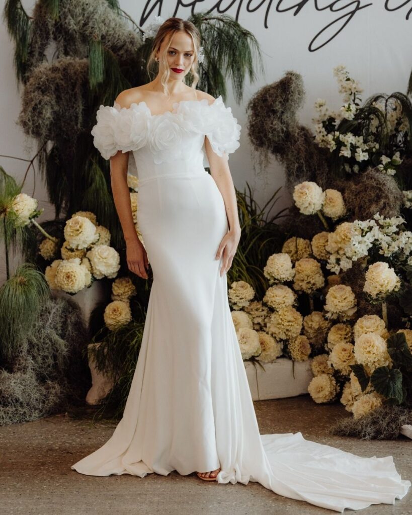 Model wearing off-shoulder silk dress with floral design on bodice at bridal runway show in Sydney 202