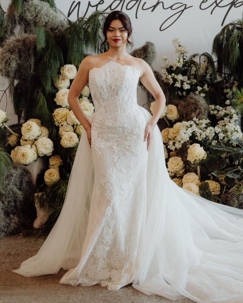 Model wearing tube-style lace bodice dress with chiffon fabric at the back at bridal runway show in Sydney 2025