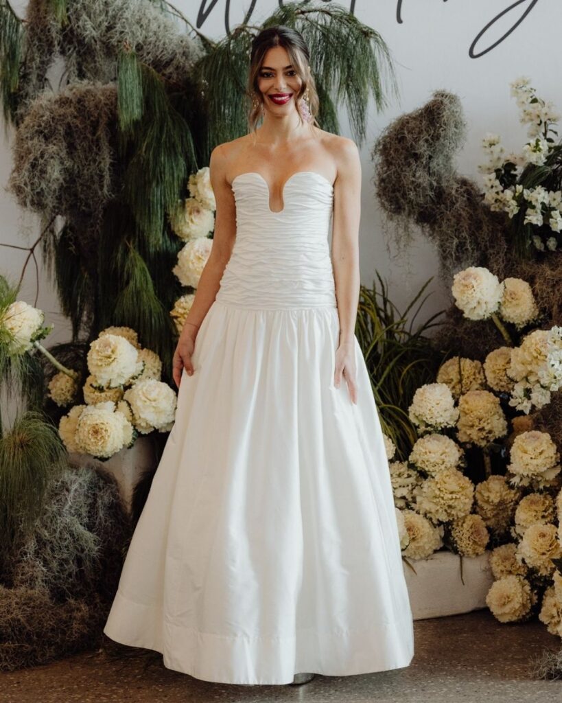 Model wearing satin gown with tube-like wrinkled top detail at bridal runway show in Sydney 2025" Clear and descriptive, includes full keyword and design detail.