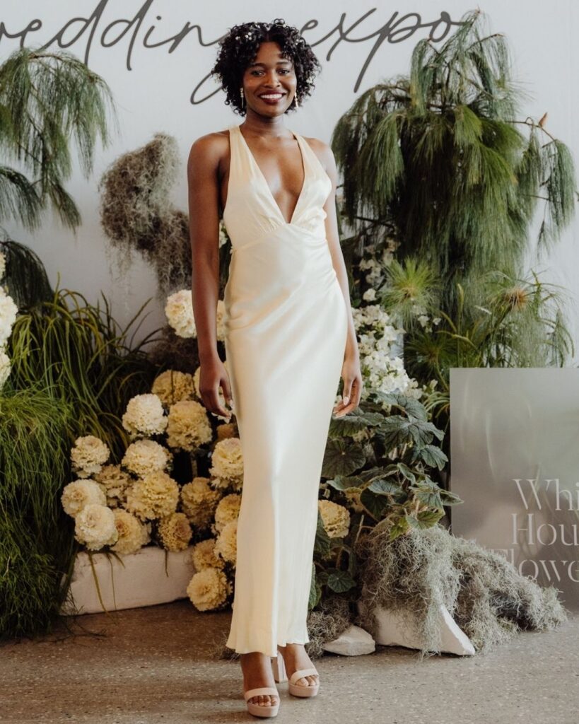 Model wearing cream satin dress with deep V-line bodice at bridal runway show in Sydney 2025