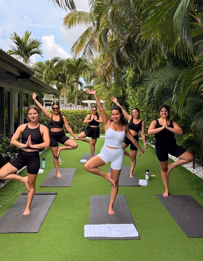 A group of women doing yoga in a backyard
