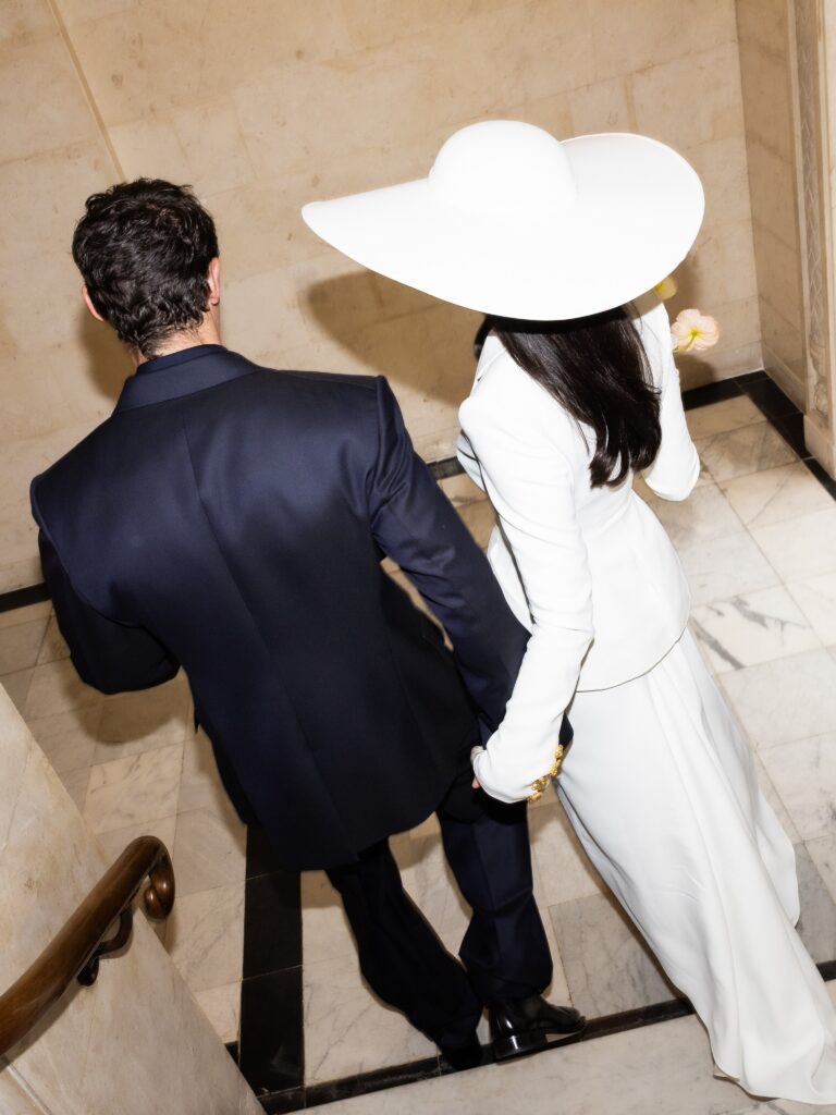 Dua Lipa and Callum Turner walking at their wedding