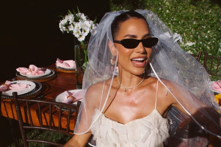 A bride wearing sunglasses and a veil laughing at her hens party in Australia