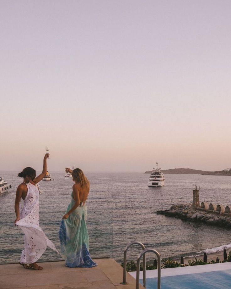 Two women dancing at sunset on a dock
