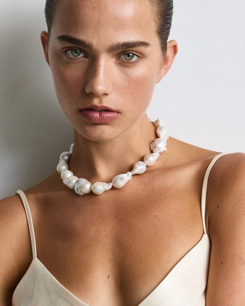 A bride wearing a large pearl necklace