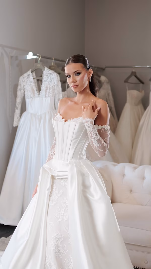 A bride at a wedding dress shop wearing a corset style bridal gown
