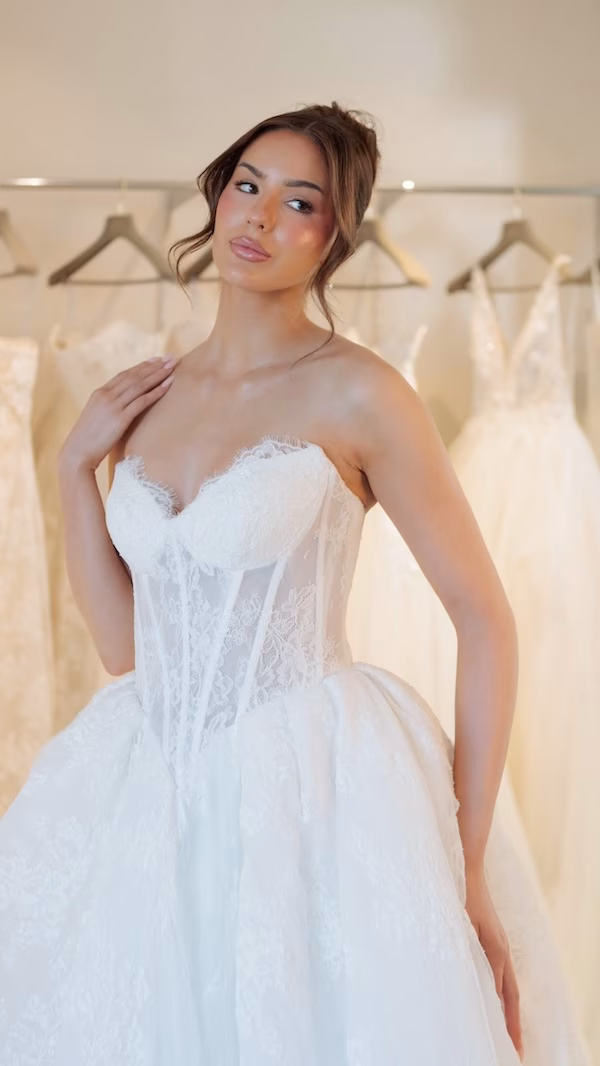 A bride at a bridal boutique wearing a sweetheart neckline wedding gown