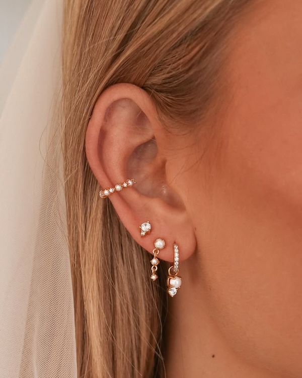 A bridal earring stack on a bride wearing a veil