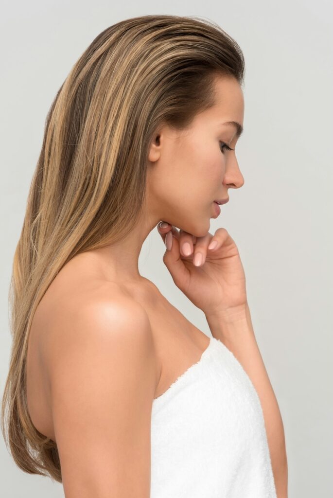 A woman in a white towel before her wedding cosmetic treatment