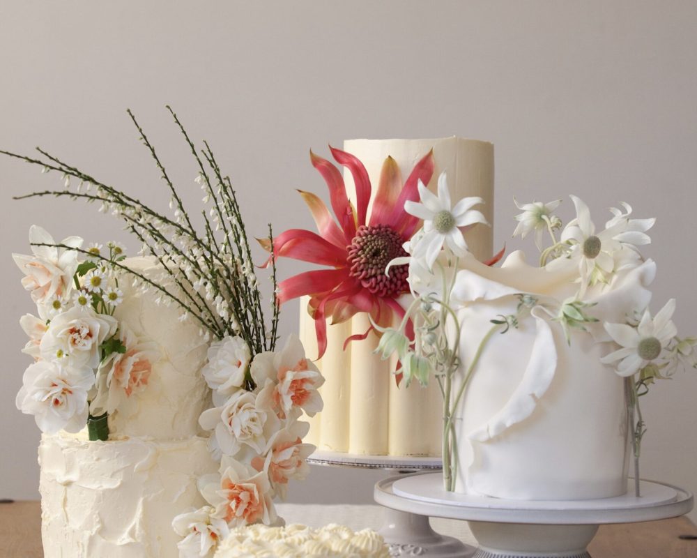 4 various wedding cakes all displayed together to show variation of designs. Native flowers used on 3 of the cakes.