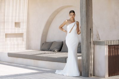 a model in a wedding dress holding on a porch with a bed on the back