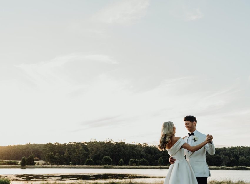 A couple dancing by a lake.