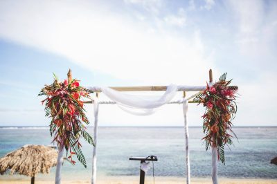 A beach wedding arch adorned with flowers, creating a romantic setting for a wedding ceremony.