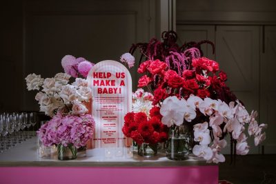 A pink table with flowers and a sign that says 