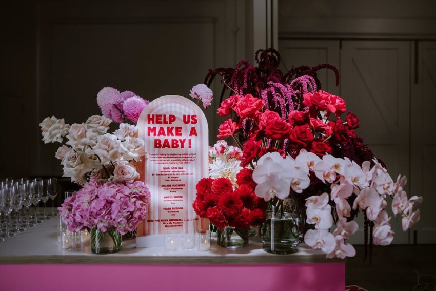 A pink table with flowers and a sign that says 